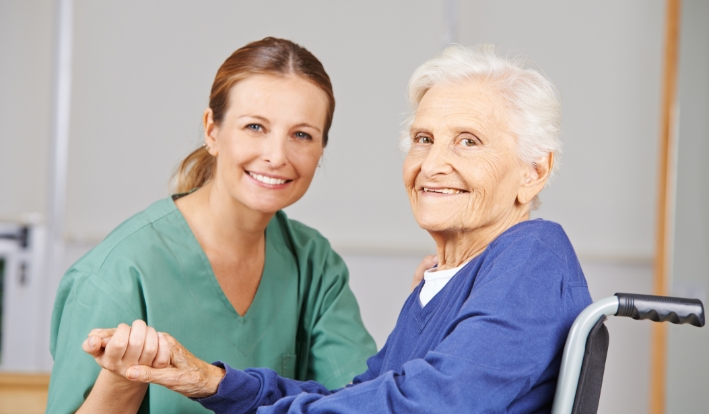 Nurse holding an elderly woman's hand
